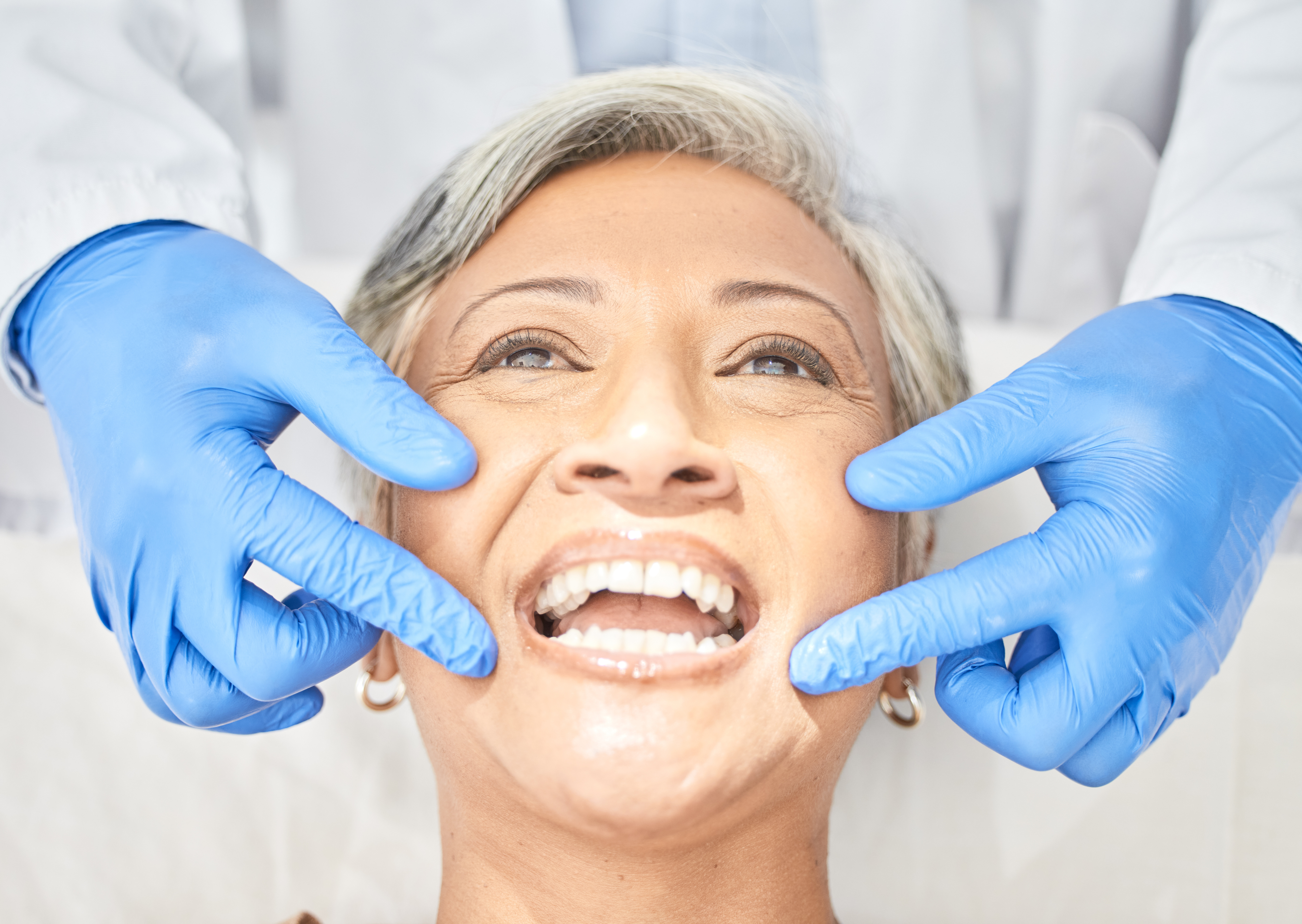Senior woman, mouth and dentist hands with dental procedure, medical and healthcare with closeup.